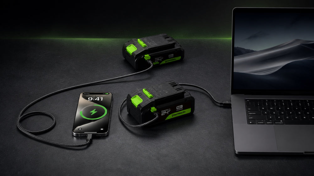 Two Greenworks PowerAll batteries powering a smartphone and laptop through USB-C